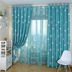 a living room with blue curtains and polka dot drapes on the windowsills