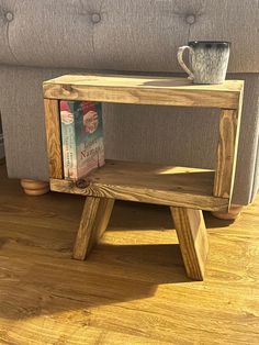 a small wooden table sitting on top of a hard wood floor next to a couch