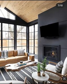 a living room filled with furniture and a flat screen tv mounted on the wall above a fire place