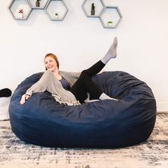 a woman is sitting on a bean bag chair