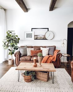 a living room filled with furniture and a wooden table on top of a rug in front of a window