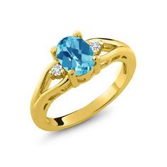 a yellow gold ring with an oval blue topazte and two diamonds on the side