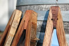 three wooden pieces of wood sitting next to each other on top of a metal barrel