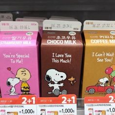 three boxes of chocolate milk for sale in a store display case with characters on them