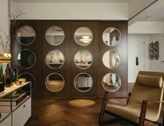 a living room filled with furniture and lots of mirrors on the wall next to a wooden floor