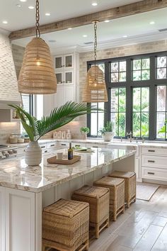 a large kitchen with white cabinets and marble counter tops, two pendant lights over the island