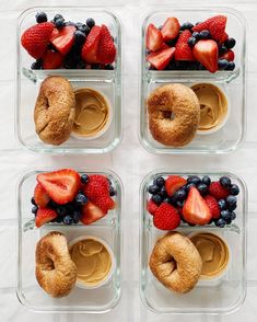 four plastic containers filled with different types of fruit on top of each other and some doughnuts in the middle