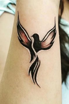 a woman's arm with a bird tattoo on it