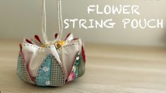 an ornament made out of fabric with the words flower string pouch on it