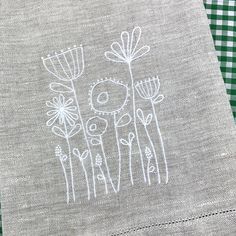 a close up of a piece of cloth on a table with flowers drawn on it