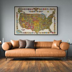 a living room with a brown couch and a large map on the wall above it