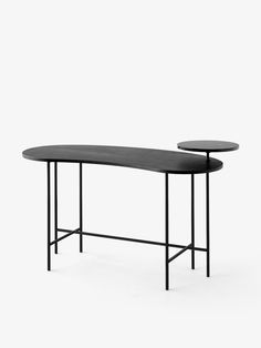 two tables with black tops and one is shaped to look like a long curved table