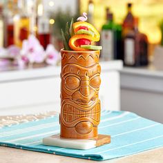 a tiki cup filled with fruit on top of a table