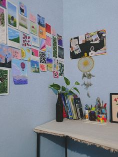 a room with blue walls and various pictures on the wall, including a vase filled with flowers