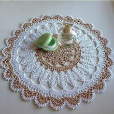 a bottle of perfume sitting on top of a doily