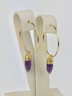 Amethyst Hoop Earrings. The perfect size hoop earrings for everyday. Beautiful amethyst points dangle from gold plated hoops. The amethyst points are capped with 24k gold electroplating. Because these are natural stones, no 2 are identical, but I will try to match them as best I can to give you a matching pair! Amethyst is the February birthstone and is believed to help with physical ailments and emotional issues. Your amethyst hoop earrings will arrive gift boxed. If this is a gift, I would be Nickel-free Purple Hoop Earrings, Purple Dangle Hoop Earrings, Amethyst Hoop Earrings Gift, Amethyst Hoop Earrings With Ear Wire, Gift, Purple Amethyst Hoop Earrings For Gift, Gift Amethyst Hoop Earrings With Ear Wire, Amethyst Dangle Hoop Earrings Gift, Purple Dangle Hoop Earrings As Gift, Small Purple Hoop Earrings As A Gift