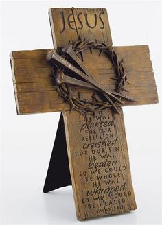 a wooden cross decorated with barbed wire and jesus's name on the front side