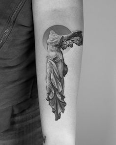 a woman's arm with an angel tattoo on the left side of her arm