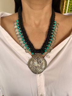 Complement your personality with this trendy unique design. Turquoise stones weaved together with tribal coins in black threads add perfect glamour to this beautiful piece. Drop Length of necklace approximately 9 inches, Non-adjustable Lobster Claw Closure Styling Tip: Wear it with a white shirt and denim jeans. Can go well with both Indian and western wear Handmade Bohemian Coin Pendant Necklace, Handmade Medallion Coin Necklace For Festivals, Handmade Bohemian Medallion Coin Necklace, Handmade Bohemian Coin Necklace, Bohemian Adjustable Black Turquoise Necklace, Black Bohemian Turquoise Necklace As A Gift, Bohemian Black Turquoise Necklace As Gift, Black Bohemian Turquoise Necklace Gift, Black Bohemian Necklace As Gift