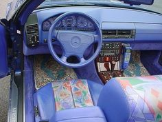 the interior of a car with blue leather seats and steering wheel, including an instrument