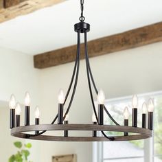 a chandelier hanging from the ceiling in a room with wood beams and windows