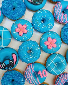 a box filled with blue and pink donuts covered in frosting