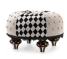 a black and white foot stool with gold studdings on the top, sitting in front of a white background