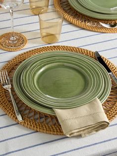 the table is set with green plates and silverware