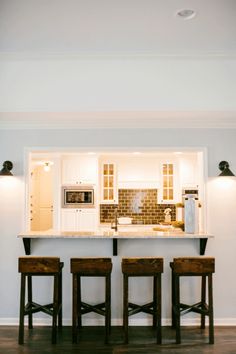 three stools sit in front of the kitchen counter