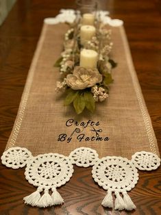 a table runner with candles and flowers on it