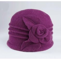 a purple hat with a flower on the front and side, sitting against a white background