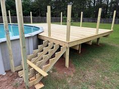 a wooden deck next to an above ground swimming pool with steps leading up to it