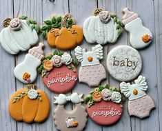 some decorated cookies are sitting on a wooden table with the words baby written in them