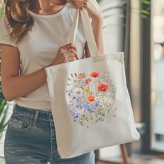 This Cotton Canvas Tote Bag features a beautiful Wildflower bouquet in an wildflower design, giving off a charming and natural vibe. Perfect for nature lovers and those who appreciate floral motifs. Ideal for carrying groceries, books, or everyday essentials. Great for eco-conscious individuals and makes a lovely gift for Mother's Day or birthdays. This 100% cotton bag comes in one size - 15" x 16"- perfect for everyday wear. While the canvas material will show off your designs in great colors, it's durable and will last for years. The bag features 20" handles (made from the same canvas), making it easy to carry even with a week's worth of shopping. .: 100% cotton canvas .: Heavy fabric (12 oz/yd² (406.9 g/m .: Sewn-in label .: Available in natural and black colors Eco-friendly Floral Canvas Bag For Everyday Use, Spring Floral Print Canvas Bag, White Flower-shaped Canvas Bag For Spring, White Flower-shaped Canvas Bag For Summer, Everyday White Floral Print Canvas Bag, White Floral Print Flower-shaped Shoulder Bag, White Floral Print Flower Shaped Shoulder Bag, Natural Color Bag For Spring Gift, Natural Color Spring Gift Bag