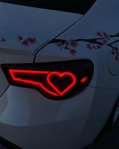 the tail light of a white car with pink flowers on it