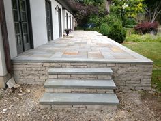 an outdoor patio with steps leading to the front door