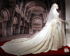 a wedding dress on display in front of a painting