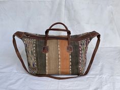 "Made to look old vintage kilim bag Vintage kilim & leather weekender bag made of berber carpet & cow hide great boho travel luggage carry on moroccan bohemian handbag Handcrafted bag by a talented artisan of Marrakech - morocco.   This is Handmade and authentic vintage moroccan leather and kilim bag.  This is a one of a kind bag, the old kilim rug was cut and then sewn on leather to give this awesome fashionable look .  This handcrafted Moroccan leather duffel features a fully-lined main compartment with zipper entry and two exterior buckled flap pockets Measures 24\" x 14\" x 11\"  Made of old kilim rug A strap Two leather pockets Comes with some minor imperfections" Bohemian Rectangular Duffle Bag With Leather Handles, Bohemian Brown Satchel Travel Bag, Traditional Brown Travel Bag With Leather Handles, Bohemian Brown Duffle Bag With Leather Handles, Bohemian Brown Leather Duffle Bag, Brown Bohemian Duffle Bag With Leather Handles, Bohemian Brown Rectangular Travel Bag, Traditional Brown Rectangular Weekender Bag, Brown Bohemian Tote Travel Bag