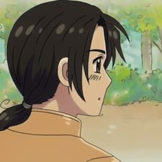 a man with black hair and ponytails standing in front of some trees looking at something