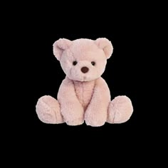 a pink teddy bear sitting down on a black background