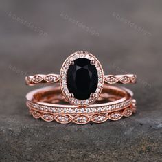 two rose gold wedding rings with an oval black diamond surrounded by smaller round white diamonds