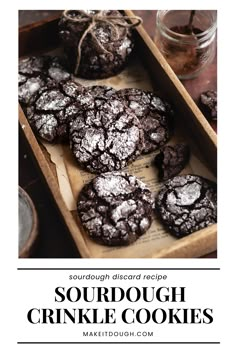 a wooden tray filled with cookies covered in powdered sugar