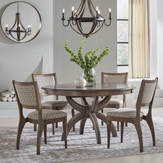 a dining room table with four chairs and a chandelier hanging from the ceiling