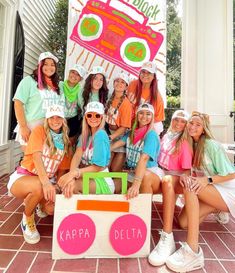 a group of girls posing in front of a sign