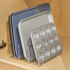 two pans are stacked on top of each other in a kitchen cabinet with metal racks