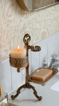 a candle is sitting on a stand in the bathroom