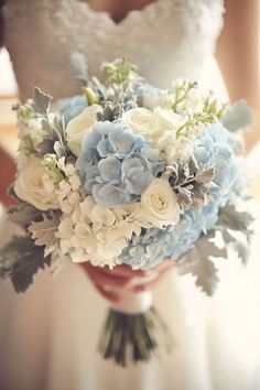 a bride holding a bouquet of blue and white flowers