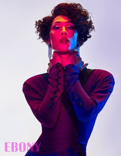 a woman with her hands on her face and wearing purple gloves, posing in front of a white background