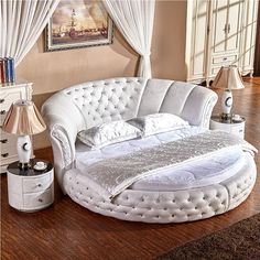 a white round bed sitting on top of a wooden floor