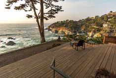 two chairs on a wooden deck overlooking the ocean